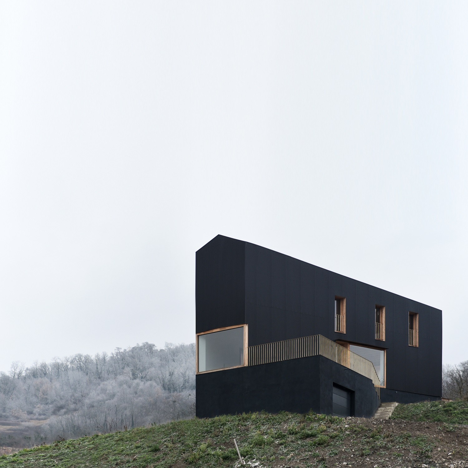 Detached House by Récita Architecture stands on the edge of the slopes of Puy-de-Mur, a distance from the surrounding rural environment