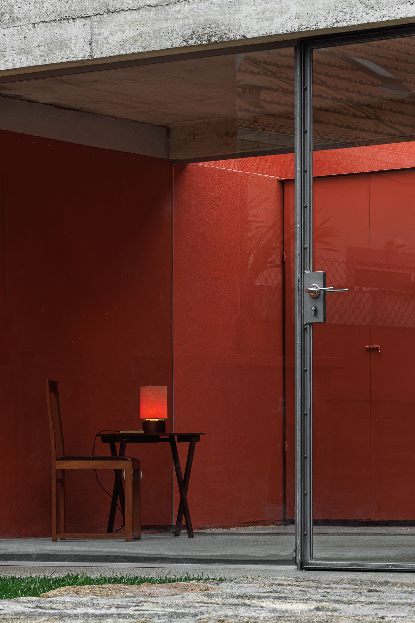 Surfaces with a red hue in the room can still be seen from the outside through its wide glass openings