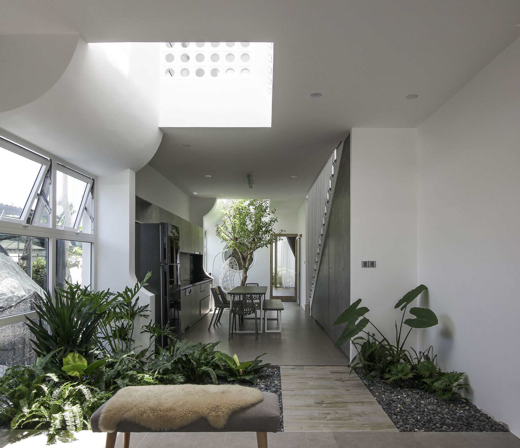 Minimalist home interior with three open inner gardens