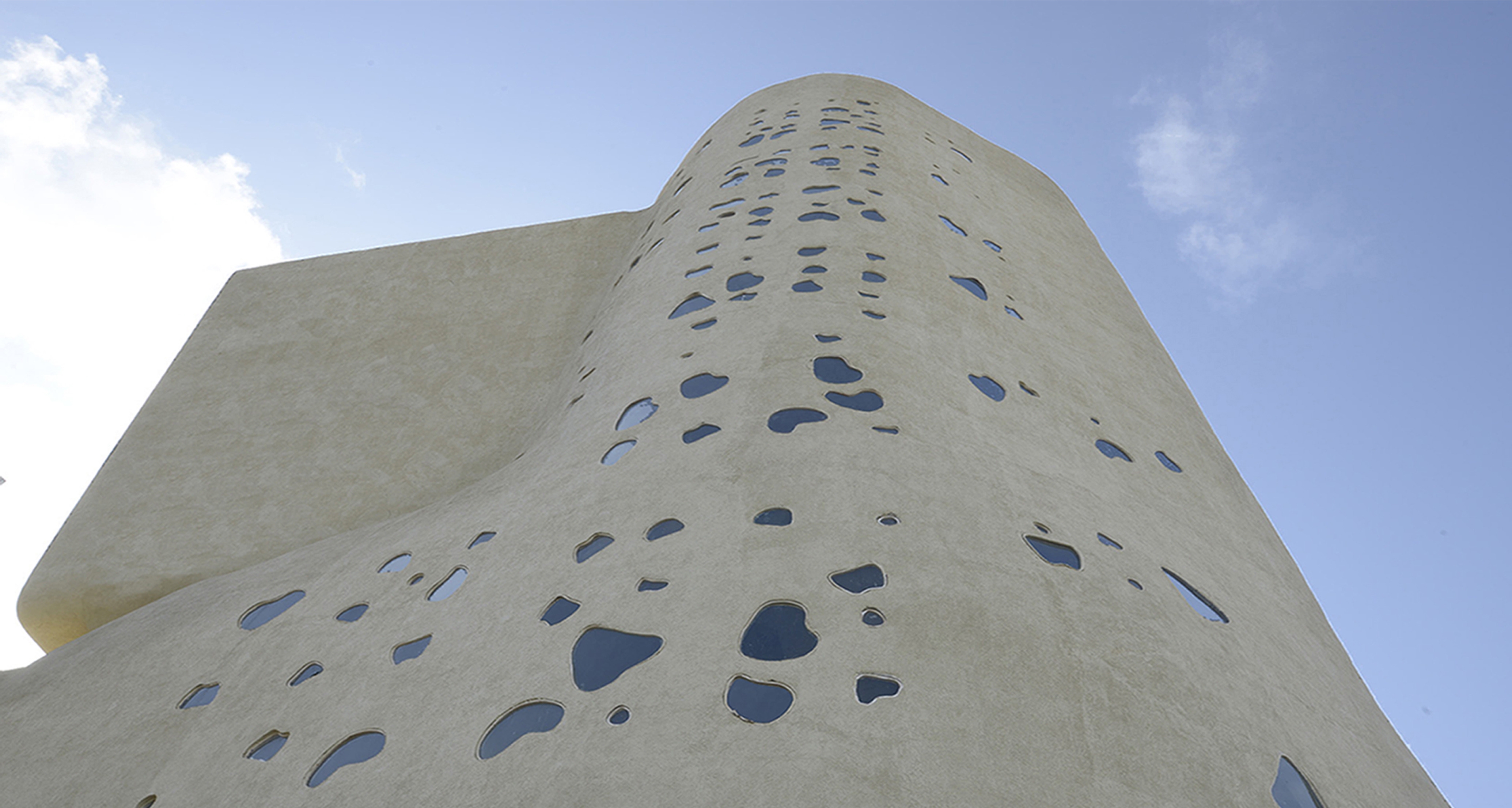 the southern facade with an abstract sprinkling of amoeboid shaped windows for the staircase