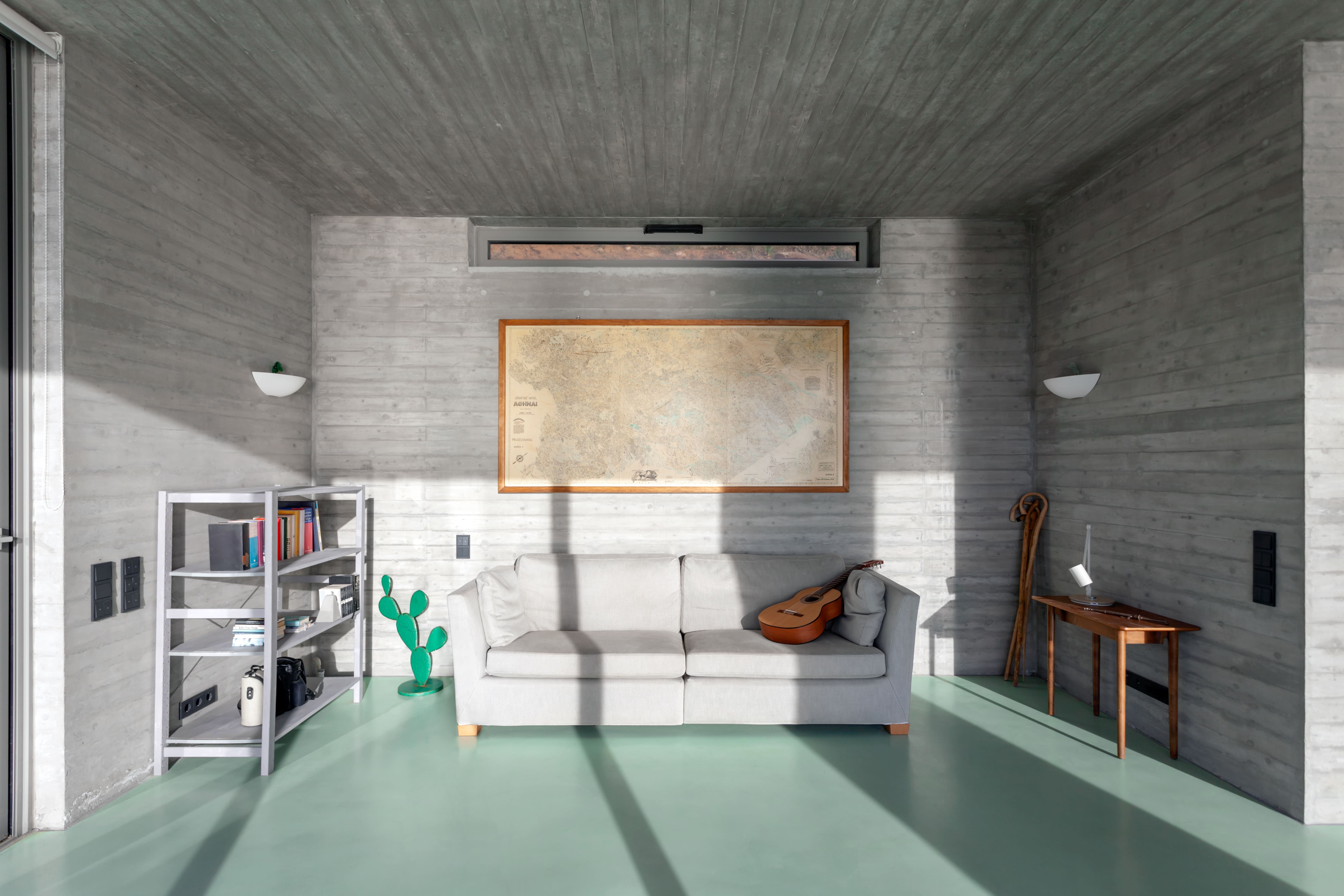 The selected furniture matches the exposed concrete color, bringing the room to life
