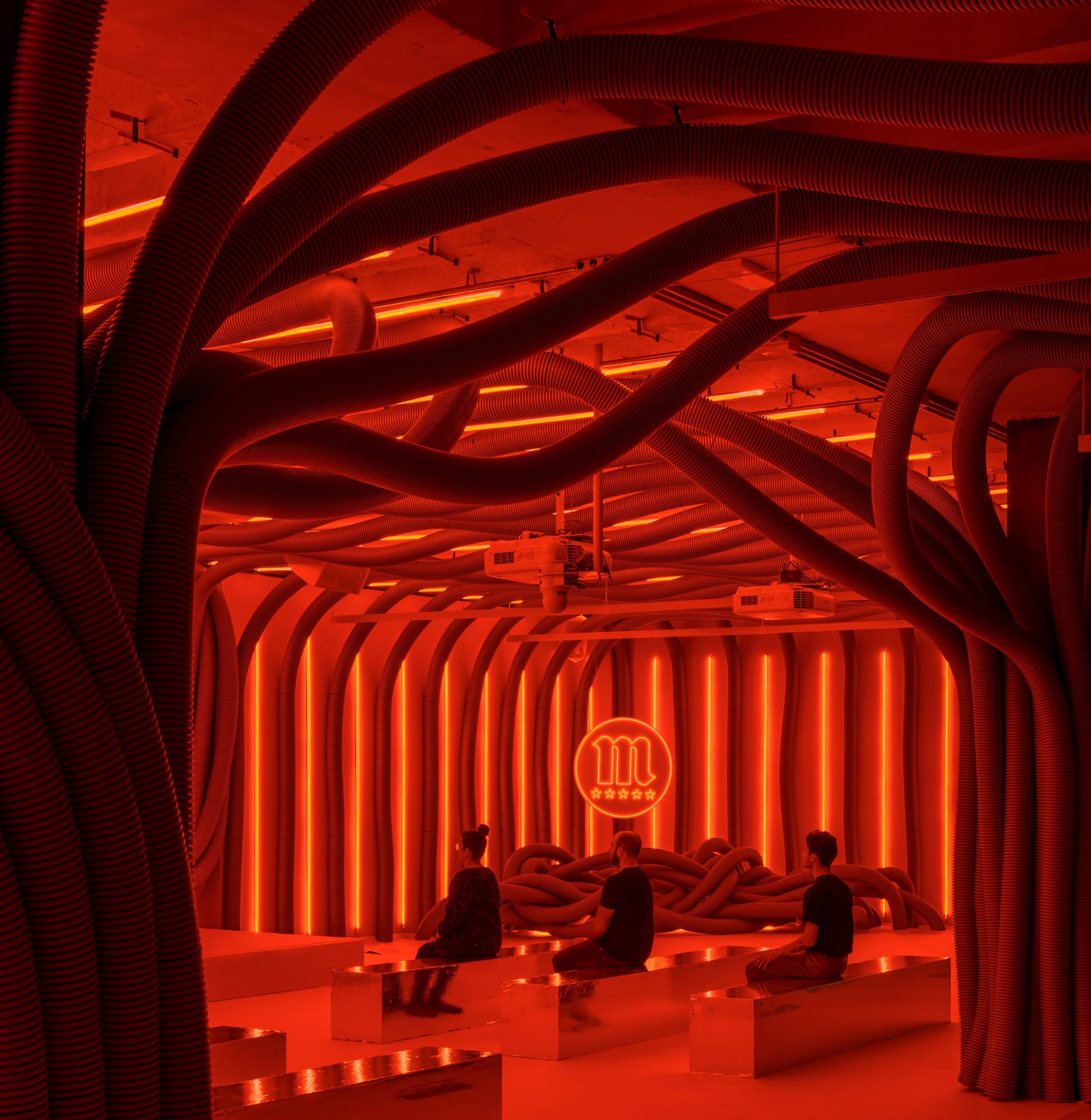 this red room is equipped with a small bar and a central seating area